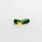 Miami Beach Fat Burner Capsules with green shell and gold powder on white background.